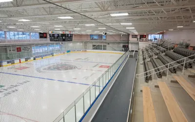 Image of Miskin Law Community Complex that shows the ice pad on the left side, and the right side, different seating options - benches and standard seating.