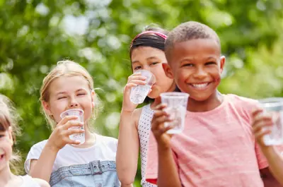 Children holding cups of water